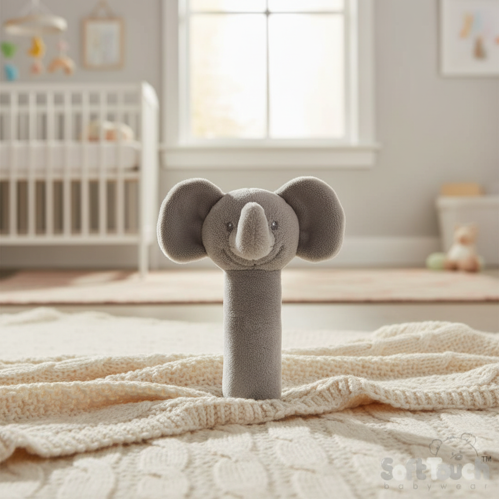 Grey elephant squeaky sensory rattle on a cream knitted blanket in a bright nursery